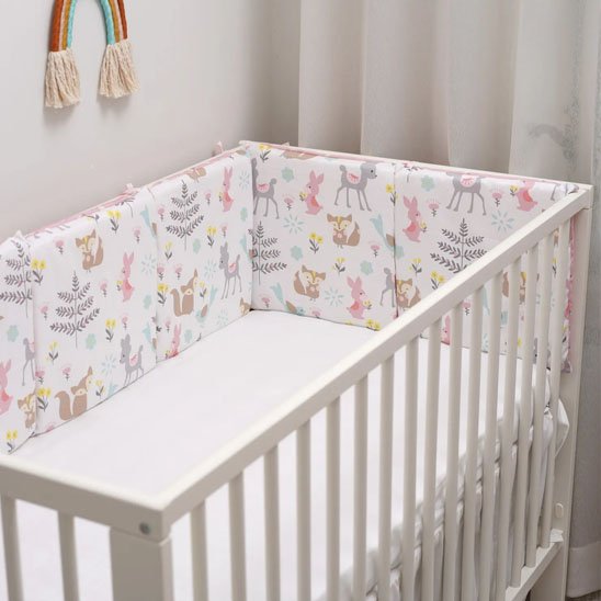 Lit de bébé avec tour de lit rembourré aux motifs de nuages et d’arc-en-ciel – chambre de bébé douce et protectrice.