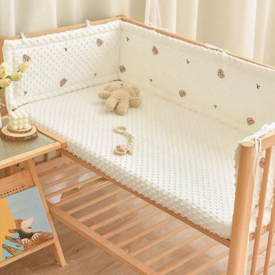 Lit de bébé avec tour de lit rembourré beige et peluche