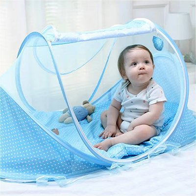 Bébé assis dans un lit moustiquaire bleu pliable, offrant protection, confort et praticité pour les parents.