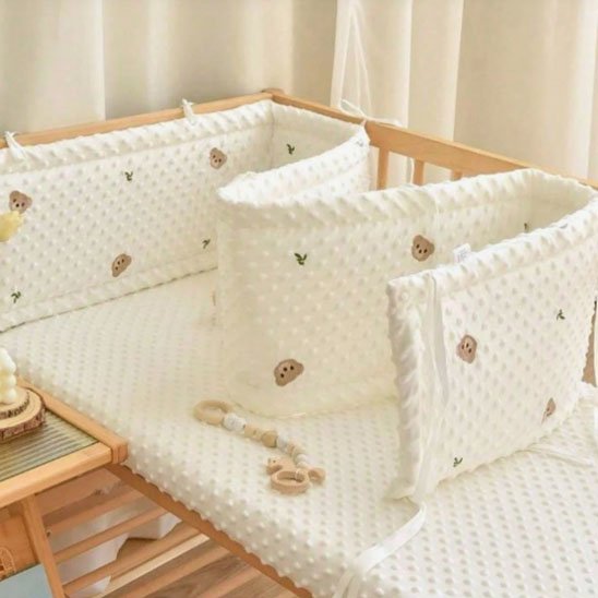 Tour de lit bébé rembourré beige à motif d’ourson, doux et protecteur pour éviter les chocs contre les barreaux.