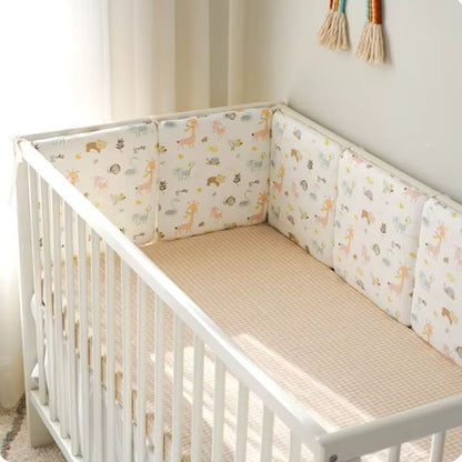  Joli lit bébé blanc avec tour de lit rembourré beige clair assurant sécurité et confort au nourrisson.