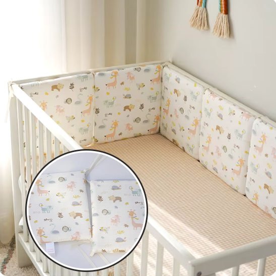 Lit bébé en bois clair décoré d’un tour de lit aux motifs d’animaux, créant une ambiance ludique et chaleureuse.