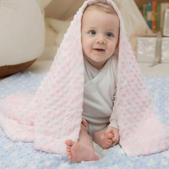 Bébé assis sur une couverture rose en tissu Minky moelleux – accessoire parfait pour la chambre de bébé