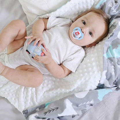 Bébé emmailloté dans une couverture grise moelleuse à motifs d’animaux – chaleur et douceur pour les siestes.