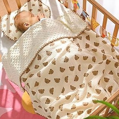 Bébé dormant dans un berceau en bois, enveloppé d’une couverture beige à motifs d’oursons marron – ambiance cocooning et apaisante.