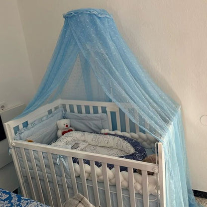 Ciel de lit bébé bleu ciel avec un voile protecteur, créant un espace paisible et sécurisé pour le bébé.