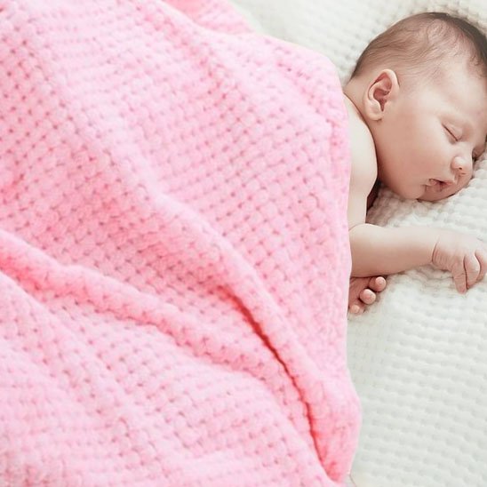  Bébé endormi paisiblement sous une couverture rose en tricot doux, idéale pour un sommeil confortable