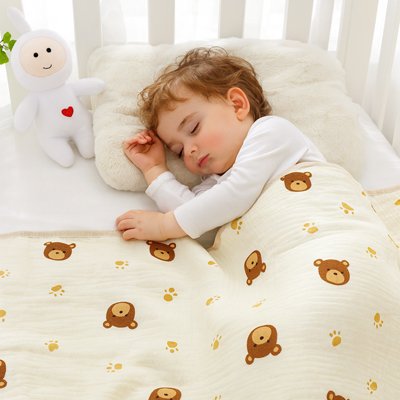 Enfant dormant paisiblement sous une couverture beige à motifs d’oursons – tissu en coton doux et respirant
