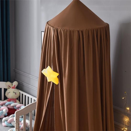 Ciel de lit bébé marron suspendu au-dessus du lit avec décor d’étoiles, pour une atmosphère magique et rassurante