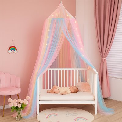 Moustiquaire décorative multicolore suspendue au-dessus du lit bébé – crée une atmosphère magique et protectrice.