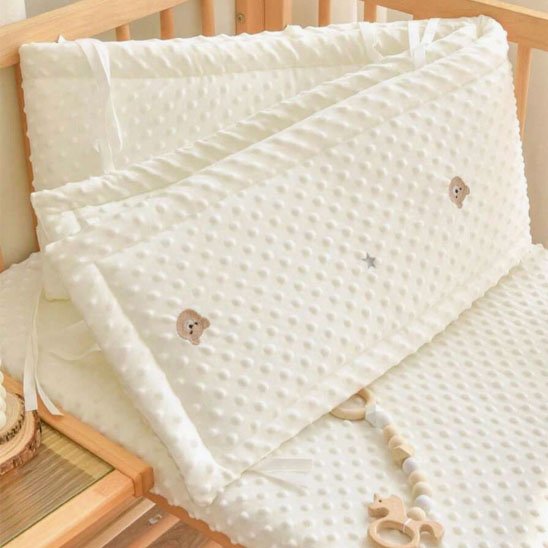 Tour de lit bébé plié, tissu beige doux à motifs d’ourson – facile à installer et à laver.