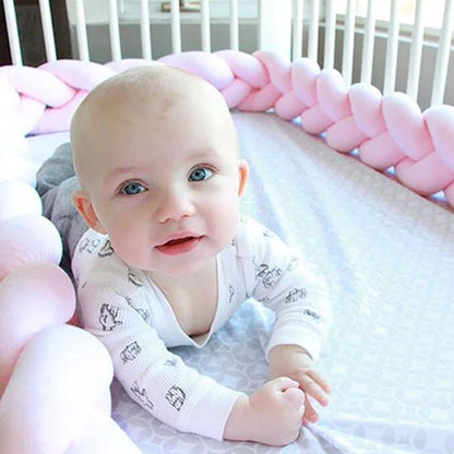 Tresse de lit bébé rose pastel avec un bébé souriant, apportant confort et chaleur à l’espace de repos